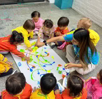 Niños con pinturas brillantes jugando sentados en el piso