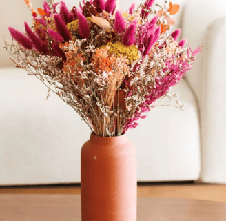 fushia and orange flowers in a terracotta vase