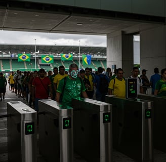 a man in a green shirt is standing in front of a line of turnstile