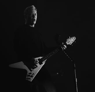 James Hetfield playing a guitar in a dark room