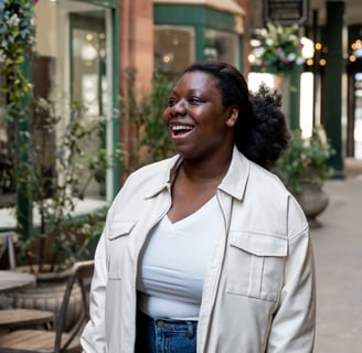 a black woman in a white jacket and jeans portrait photography