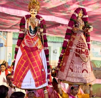Two women with Gangaur Devi Devta on their heads, accompanied by the Manohar Brass Band.