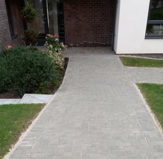 a driveway with a brick walkway and a brick walkway