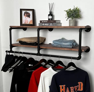 a floating 2-tier shelf on a wall organizing clothes