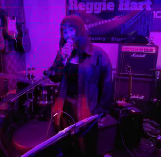a wpman in a blue shirt is holding a microphone and singing into a microphone