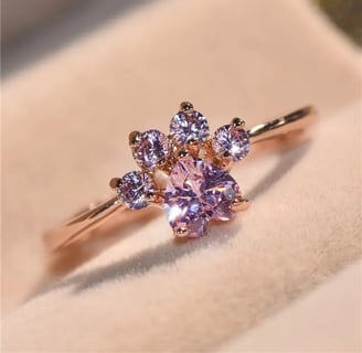a pink ring with a pink cat themed paw ring