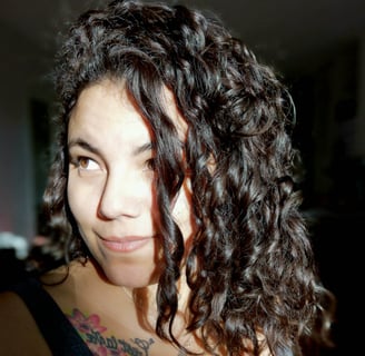 Portrait de Suzi Santana, regard éveillé et tatouage de rose, symbole de reconnaissance intuitive