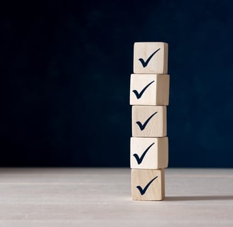A stack of wooden blocks with tick check marks on them
