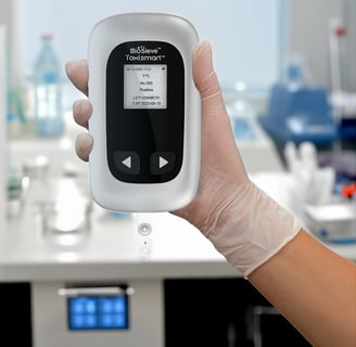 ToxiSmart multi-drug fluorescent immunoassay reader shown held in hand for scale