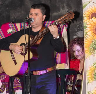 a man in a mexican costume playing guitar