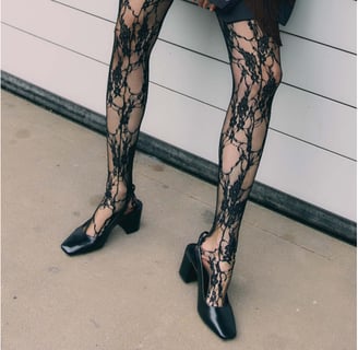 a woman in a black dress and black shoes