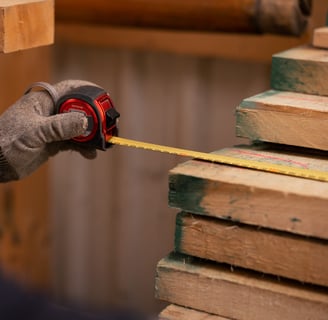 a person holding a tape measure ruler and measuring tape measure tape on wood wood plank