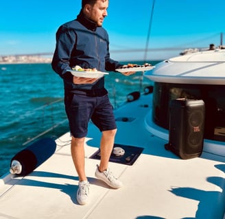 Notre Capitaine proposant des sushis à nos invites lors d'une balade en bateau sur notre catamaran L