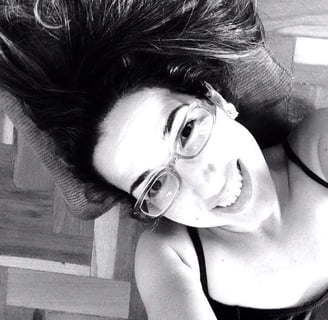 A professora Juliana, uma mulher com óculos de cabelos pretos com um sorriso no rosto.