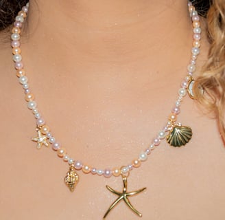 a woman wearing a white dress and a necklace with a starfish
