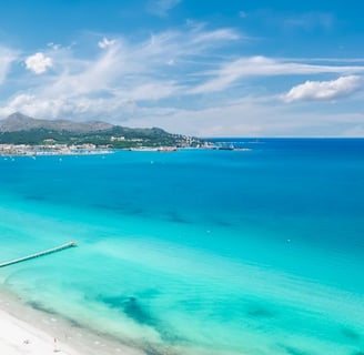 Scenic view of Alcudia Bay on a clear day, popular boat tour destination in Mallorca