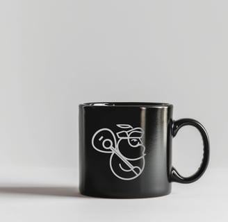 Caneca preta com logo branco de produtora musical com homem barbudo segurando violão