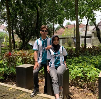 a man and woman sitting on a bench in a park