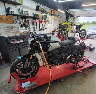 Motorcycle and dirt bike on service lifts in shop