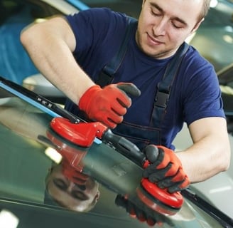 a man in a blue shirt is using a machine to polish a car