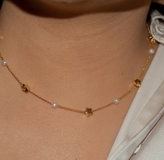 a woman wearing a white shirt and a gold necklace