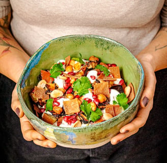 a woman holding a bowl of Lebanese food