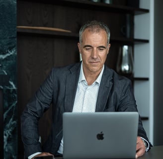 a man in a suit and tie is sitting at a desk