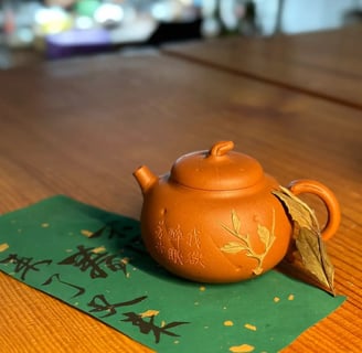 A brown teapot placed on green paper with text written on it