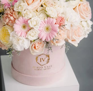 Elegant pink and white floral arrangement in branded pastel pink box