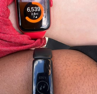 two people wearing a red and black watch on their wrist.