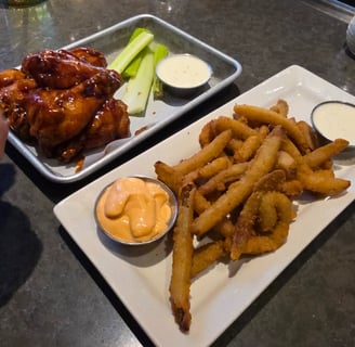 plate of Fryckle fries, ranch, barbeque wings, and celery
