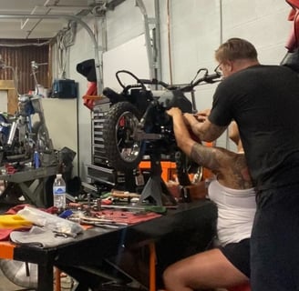 woman and man wrenching on a motorcycle