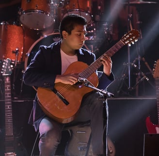 Gurnee Guitar Academy Guitar Lessons a man playing classical guitar in a concert