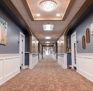 a hallway with a carpeted floor and a chandelier