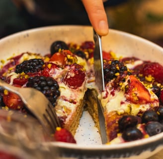 a person cutting into slices of fruit on a plate