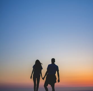 a couple holding hands while standing on a hill