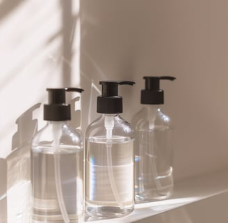 three bottles on a shelf in a bathroom