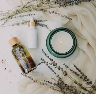 Candle, lavender, and herbal oil flatlay