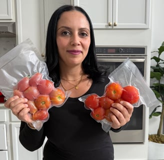 By eya holding a bag with whole frozen tomatoes 