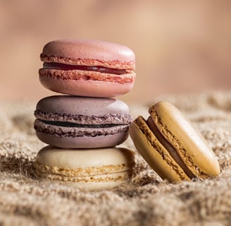 4 macarons dont trois empilés sur toile de jute et fond marron clair