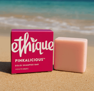A bar of Ethique Pinkalicious shampoo sitting in the golden sands of a Thai beach