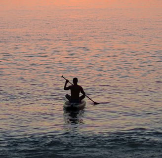Travel writer Rick Silvia paddles into the sunset by kayak in the bay of Bang Tao