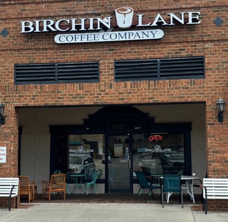 A brick building with a sign reading Birchin Lane Coffee Company