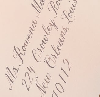 light pink envelope with an address written in calligraphy script in brown ink