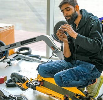 a man fixing an escooter in a garage