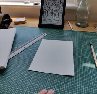 Eleanor's (elsillustrations) hand holding a pen and a tablet with a sketch of the save the dates