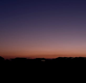 a person standing on a hill with a sky background