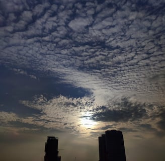 a cloudy sky with a few clouds and a plane flying in the sky