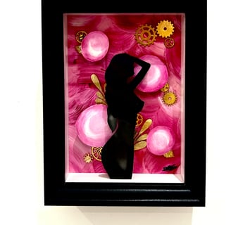 a woman in a black dress standing in front of a pink flower
