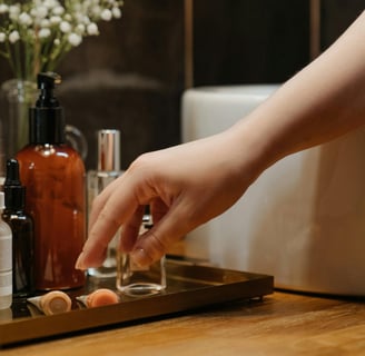 A person about to pick a cream or a serum out of several on a bathroom cabinet.